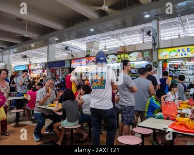 Singapore – 4 GENNAIO 2020 – i clienti asiatici cinesi hanno un pasto e socializzano in un affollato centro di falchi self-service ad Ang Mo Kio, Singapore, Southeas Foto Stock