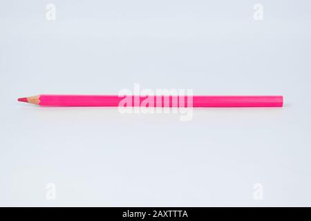 Pastello a matita rosa singolo in legno affilato posto su uno sfondo bianco isolato Foto Stock