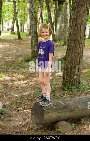 Ragazza giovane bambina bambino su un bambino ostacolo corso attività Trail in bosco foresta albero, in un parco avventura in Francia durante l'estate. (112) Foto Stock