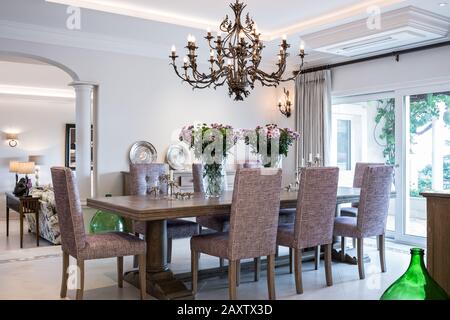 Sala da pranzo con sedie viola e lampadario Foto Stock
