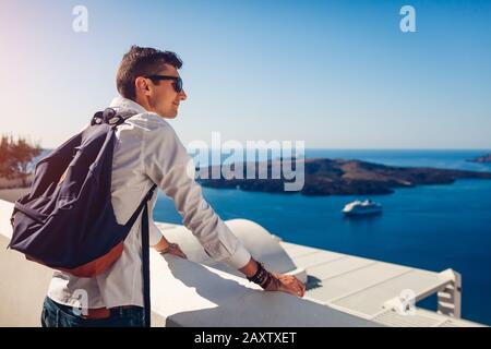 Uomo viaggiatore di Santorini che gode di vista sulla Caldera da Fira o Thera, Grecia. Turismo, viaggiare, concetto di vacanza Foto Stock