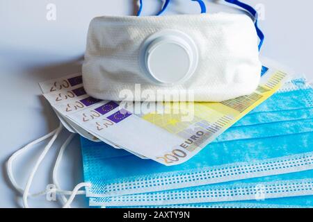 Maschere mediche e banconote da 200 euro come simbolo di un aumento dei prezzi per la protezione del tratto respiratorio dai virus. Foto Stock