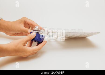 La mano della donna che prende le pillole dal blister quotidiano della confezione. Farmaci per pazienti in ospedale. Foto Stock