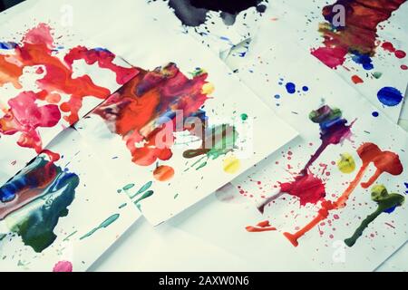 Molti blot di colore rosso su carta bianca con striature. Punti creativi astratti di vernice su sfondo bianco. Colori rosso brillante. Tabella macchiata-frantumata Foto Stock