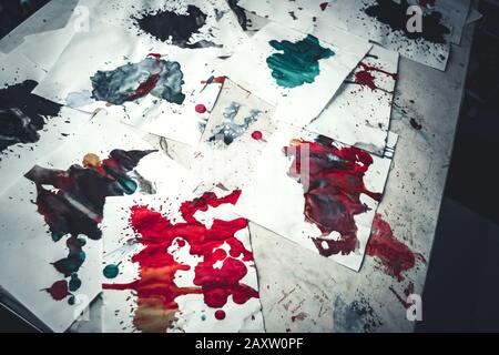 Molti blot di colore rosso su carta bianca con striature. Punti creativi astratti di vernice su sfondo bianco. Colori rosso brillante. Tabella macchiata-frantumata Foto Stock