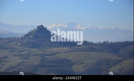 Il Castello di Rossena, nella leggera nebbia mattutina, sullo sfondo delle montagne innevate Foto Stock