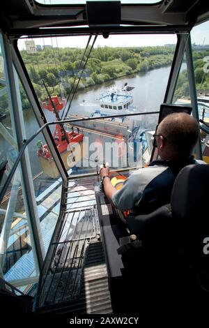 All'interno della gru Liebherr gli operatori caricano i container nella nave da carico Foto Stock