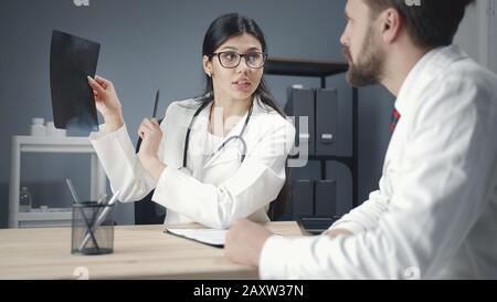 Medici che esaminano la fotografia a raggi X. Foto Stock