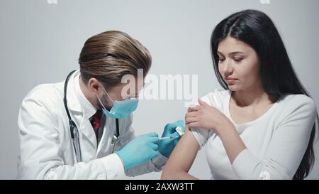 Medico che dà la vaccinazione al paziente Foto Stock