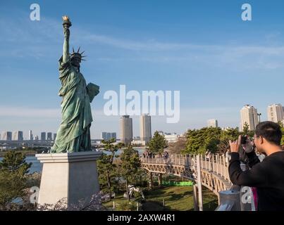 Giappone, Tokyo: Uomo che fa una foto di una replica della Statua della libertà in Obaida nella Baia di Tokyo Foto Stock