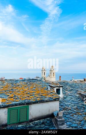 I caratteristici campanili gemelli della chiesa di San Giovanni Battista, in Bastia, Corsica, Francia, evidenziando al di sopra del vecchio dei tetti di ardesia della vecchia Foto Stock