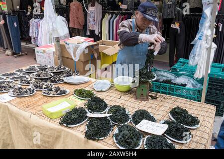 Giappone, Tokyo: Atmosfera a Jizo Dori nel quartiere di Sugamo, distretto per la generazione più vecchia. Uomo che vende alghe marine Foto Stock
