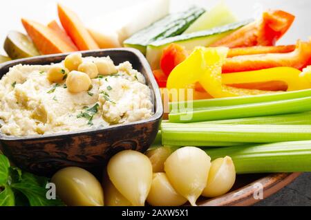 Vista a basso angolo su piatto di verdure con hummus condito con ceci e olio d'oliva Foto Stock