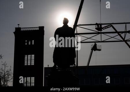 Berlino, Germania. 13th Feb, 2020. Solo come sagome sono il monumento Schinkel i resti di un ponteggio in acciaio su cui l'edificio progetta con il manichino dipinto di Karl Friedrich Schinkel Bau-Akademie appeso. I lavoratori smontano i puntoni dalle gru di sollevamento. L'edificio, inaugurato nel 1836, sarà ricostruito per 62 milioni di euro. Baucontoiner si trova direttamente presso l'edificio. Tuttavia, non è chiaro quando inizierà la costruzione. Credito: Paul Zinken/dpa/ZB/dpa/Alamy Live News Foto Stock