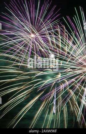 L'esplosione del display Firework crea un contrasto colorato di colori e movimenti sfocati contro un cielo notturno oscurato. Spettacolare vista a Baltimora MD. Foto Stock