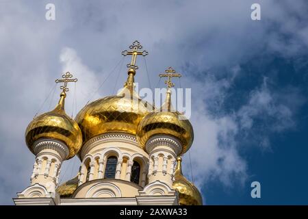 Cupole dorate della Cattedrale di St. Alexander Nevsky contro un cielo blu e nuvole bianche. Foto Stock