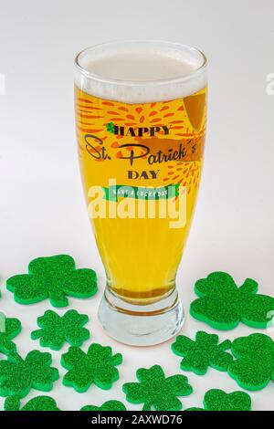 Giorni di San patrizio birra Pinta con un cappello verde e i trifogli intorno Foto Stock