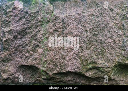 Struttura in pietra di granito. La superficie irregolare è scura e di colore grigio chiaro. Pietra naturale naturale per sfondo. Foto Stock