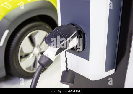 La ricarica della batteria per le auto nuove innovazioni nel settore automobilistico l'alimentatore inserito in un auto elettrica essendo caricato, il concetto di energia innovat Foto Stock