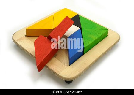 Tangram, tradizionale gioco di puzzle cinese fatto di diversi pezzi di legno colorato che si uniscono in una forma distinta, in una scatola di legno. Isolato su Foto Stock