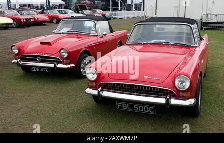 Vista frontale di tre quarti di due Red, 1965, Sunbeam Tigers (versioni Mk1 e Mk 2), in mostra al 2019 Silverstone Classic Foto Stock