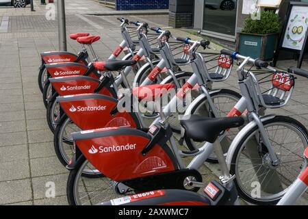 Santander biciclette a noleggio a Central Milton Keynes, Regno Unito; l'azienda ha una lunga associazione con la città con la sua sede centrale lì. Foto Stock