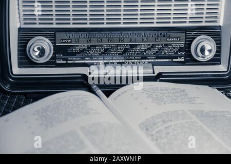 Vista frontale di una radio Blaupunkt vintage dalla 60s, visibile un libro e una matita, immagine monocromatica. Foto Stock