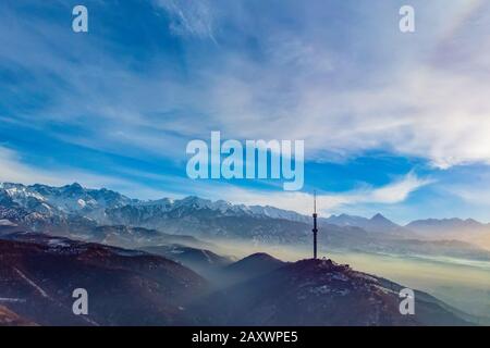 Paesaggio di montagne con una torre TV nelle vicinanze di Almaty. Kazakistan. Inverno. Cattiva situazione ambientale Foto Stock