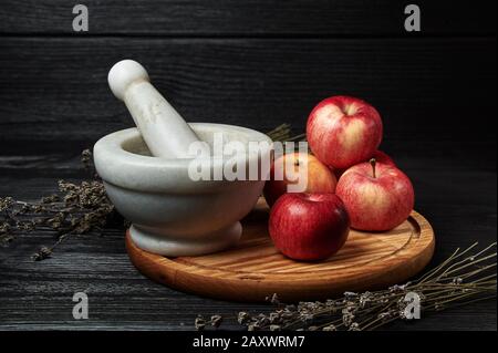 ancora vita, mele su uno sfondo nero circondato da fiori secchi Foto Stock