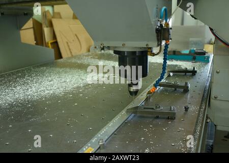 Fresatrice a controllo numerico per computer per lavori, foratura di foratura in un pezzo metallico, primo piano Foto Stock