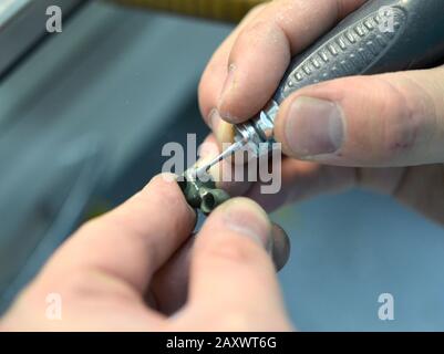 Dentista mulini a mano corone di denti creato su 3d stampante per il metallo. Dentista che lavora con corone ceramiche in laboratorio dentale Foto Stock