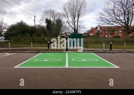 Woodbridge, Suffolk, Regno Unito - 13 febbraio 2020: Due parcheggi dipinti di verde e un punto di ricarica per auto elettriche nel parcheggio Station Road. Foto Stock