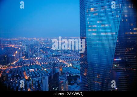 Vista aerea di Shanghai di notte e riflessi della luce della città in vetro facciata su edificio moderno. Foto Stock