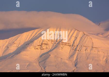 Cima di montagna innevata al tramonto a Billefjorden, fiordo centrale dell'Isfjorden, Svalbard / Spitsbergen, Norvegia Foto Stock