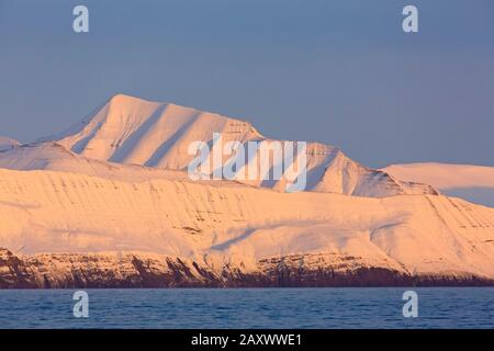 Montagne innevate a Billefjorden al tramonto, fiordo centrale dell'Isfjorden, Svalbard / Spitsbergen, Norvegia Foto Stock