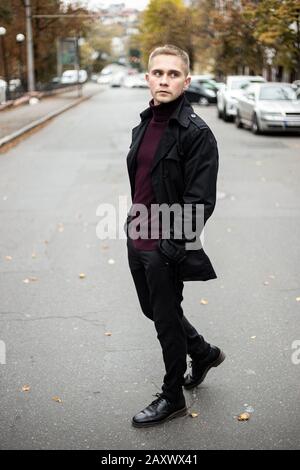 Uomo alla moda con camice nero e collo di polo viola Foto Stock