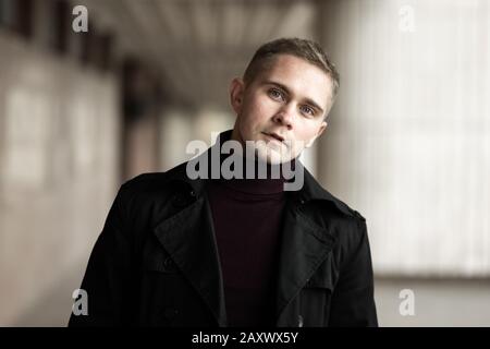 Uomo alla moda con camice nero e collo di polo viola Foto Stock