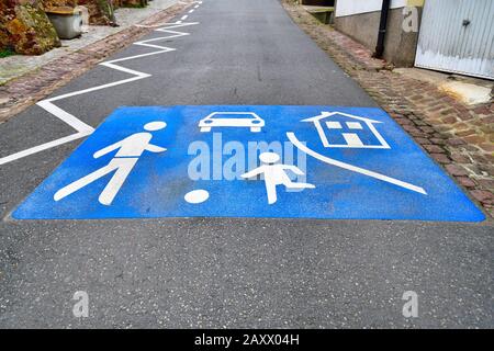 Simbolo di strada blu con giochi per bambini e auto dipinta su strada in Germania Foto Stock