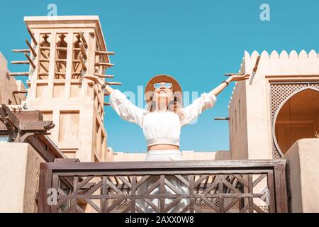 Felice ragazza turistica asiatica cammina attraverso la vecchia città araba a Dubai, Emirati Arabi Uniti Foto Stock