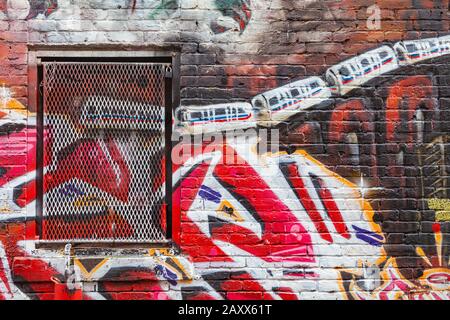 Graffiti dipinto sulle pareti di mattoni di un vicolo posteriore nel quartiere Gastown di Vancouver Canada Foto Stock