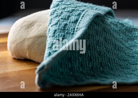 Pasta per pizza appoggiata su buccia di legno. Foto Stock