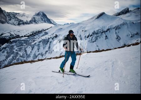 Un alpinista di sci che arrampica una montagna con gli sci. Svizzera. Foto Stock