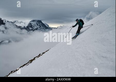 Tour sciatore sci in discesa in Oberland Bernese, Svizzera. La famosa faccia nord dell'Eiger è visibile dietro. Foto Stock