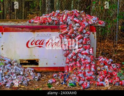 Cola Lattine Accatastate Intorno A Old Cooler Foto Stock