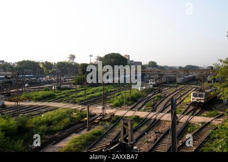 Guardando giù da un ponte su una moltitudine di binari ferroviari con un passaggio pedonale e molte carrozze ferroviarie, con lavoratori carico e scarico Foto Stock