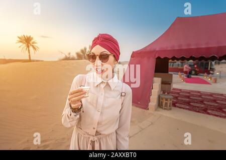 Donna Musulmana con degustazione di caffè arabo durante il tour ed escursione nel deserto medio orientale Foto Stock