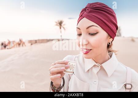 Donna Musulmana con degustazione di caffè arabo durante il tour ed escursione nel deserto medio orientale Foto Stock