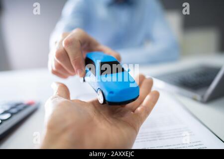 Primo Piano Della Mano Del Venditore Che Dà L'Automobile All'Uomo Foto Stock