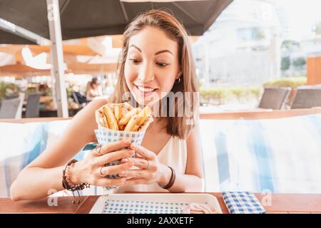 ragazza in street food caffè mangia gustosi e succosa giros con pita. Concetto di cucina mediorientale Foto Stock