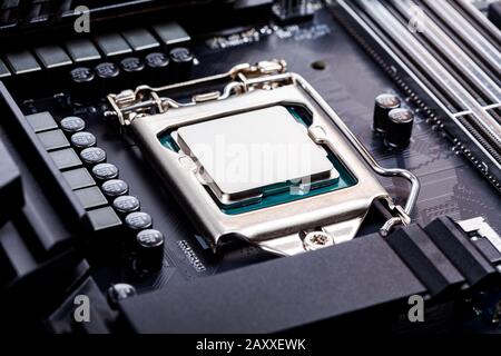 Coperchio della CPU vuoto, coperchio del socket, angolo di visualizzazione del processore posizionato e bloccato nel socket su una nuovissima scheda madre per la produttività di gioco di fascia alta moderna Foto Stock